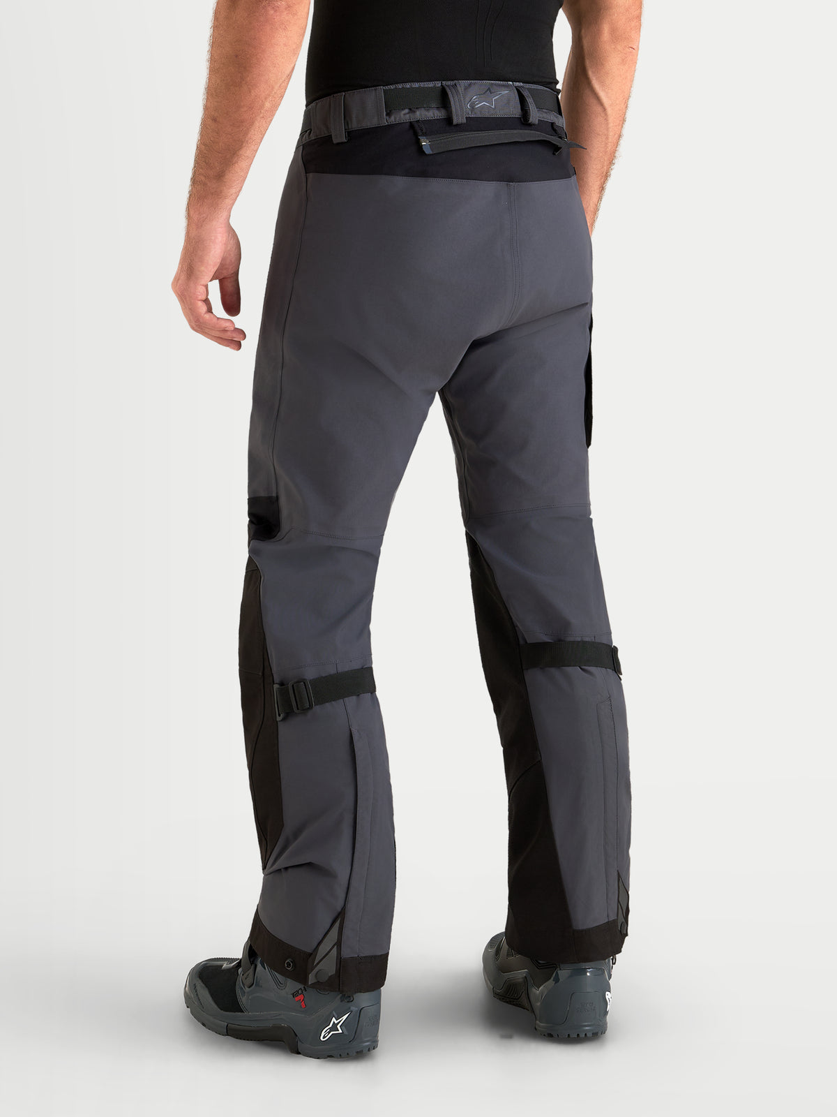Alpinestars Arenis Gore-Tex Hose, Herren-Adventure-Motorradhose in Schwarz und Dunkelgrau, Rückansicht an einem Model mit wasserdichter Textilkonstruktion und Taillenverschluss
