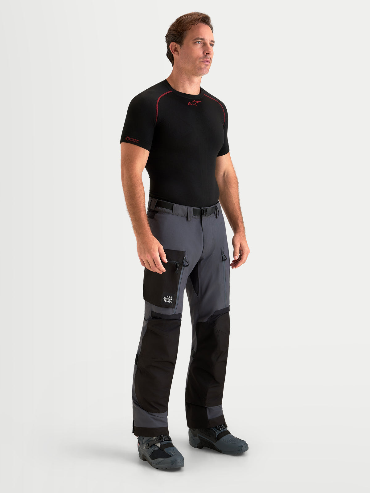 Alpinestars Arenis Gore-Tex Hose, Herren-Abenteuer-Motorradhose in Schwarz und Dunkelgrau, Vorderansicht an einem Model mit technischer Textilkonstruktion und Cargo-Tasche