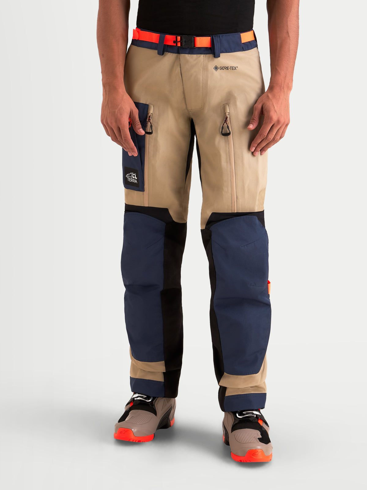 Alpinestars Arenis Gore-Tex Hose, Herren-Abenteuer-Motorradhose in Navyblau und Beige, Vorderansicht an einem Model in wasserdichter Textil-Schutzausrüstung mit Oberschenkelbelüftung und verstärktem Knieschutz