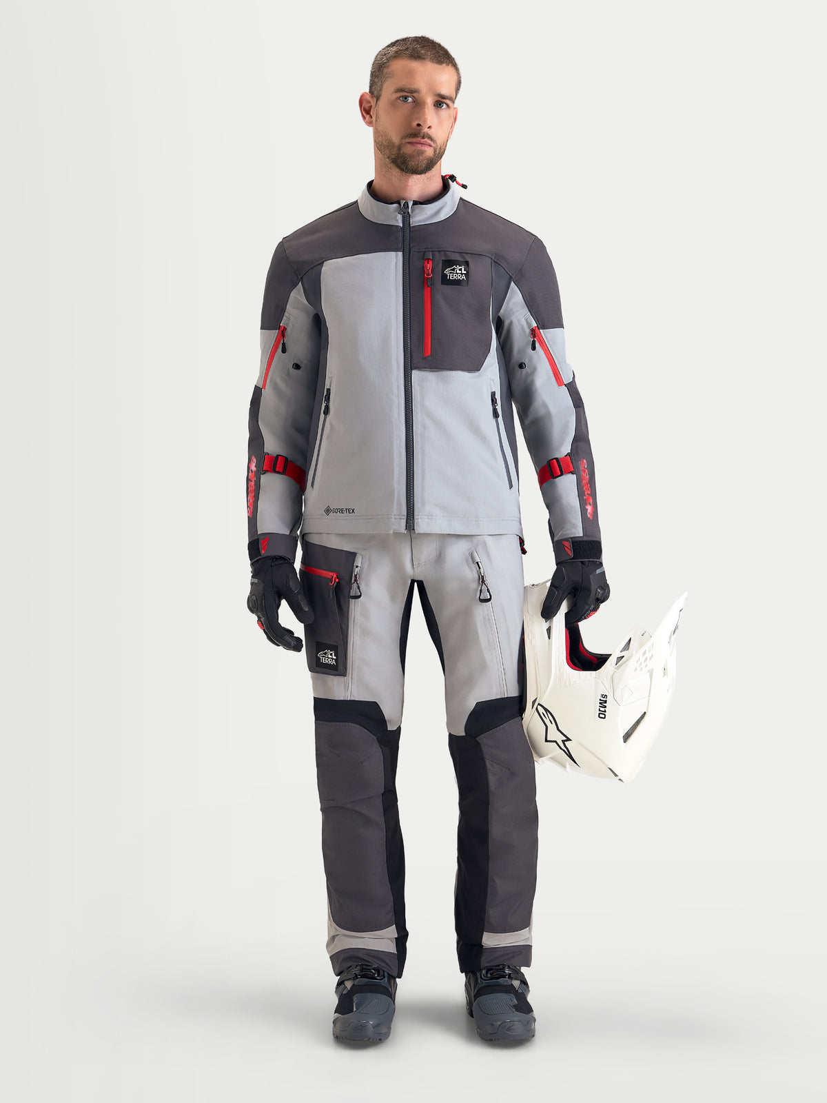 Alpinestars Arenis Gore-Tex® Pants, men's adventure touring motorcycle pants in mid gray, deep gray, and black, front view on a model wearing matching jacket and helmet, AA certified waterproof all-terrain riding apparel