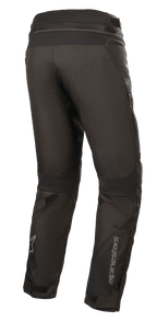 Alpinestars Road Pro GORE-TEX Pants, Black Motorcycle Pants, back view showing tapered touring fit, technical textile construction, Alpinestars branding on lower leg, accordion stretch panels, and adjustable straps for adventure touring.