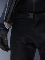Alpinestars ST-7 2L GORE-TEX Hose, Schwarz, Nahaufnahme der Taille mit Magnetverschluss und robuster technischer Textilkonstruktion, getragen mit passender Adventure-Tourenjacke und schwarzen Handschuhen mit rotem Logo