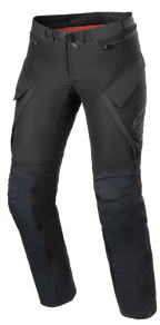 Alpinestars Damen Stella ST-7 2L GORE-TEX Hose, Adventure-Touring-Motorradhose, Schwarz und Dunkelgrau, Vorderansicht mit Cargotaschen, Magnetverschluss am Bund, vorgeformte Knie mit Protektorenpositionierung und dezentes Alpinestars-Branding am Oberschenkel.