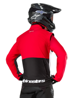Alpinestars Pro-Dura Jacket, Off-Road Enduro Jacket, Red and Black with white Alpinestars logo on back hem, worn by rider from behind with a black motocross helmet, rally-inspired design for aggressive trail riding