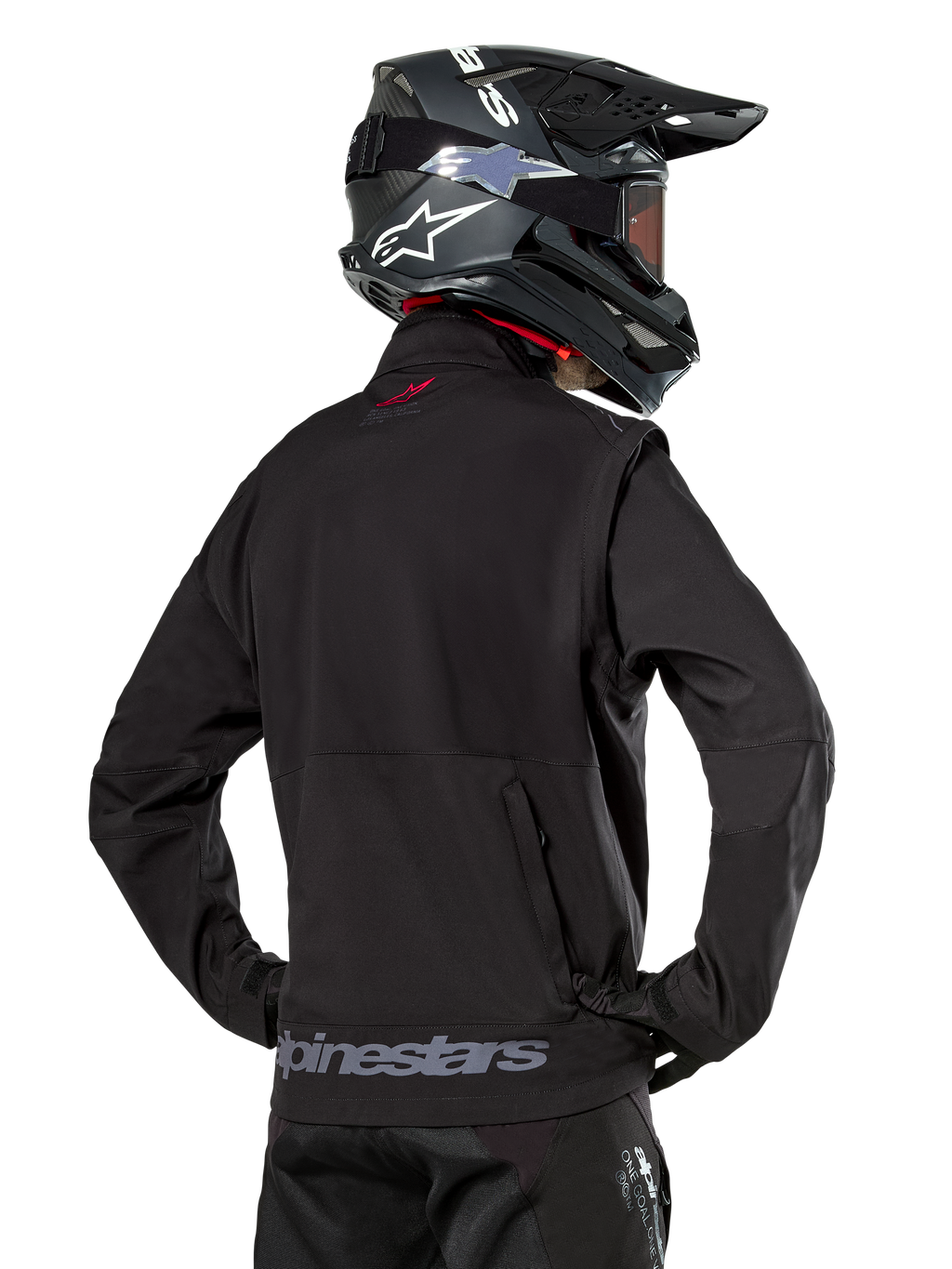 Alpinestars Lite-Dura Softshell Jacket, Black, back view worn by a rider, featuring gray Alpinestars branding on the rear hem and a small red logo on the collar, paired with a black motocross helmet, designed for enduro and off-road riding.