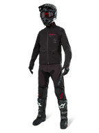 Alpinestars Lite-Dura Softshell Jacket, Black, worn by a mannequin as part of a complete off-road gear set including black pants, black and white boots, black helmet with red goggles, professional motocross and enduro apparel.