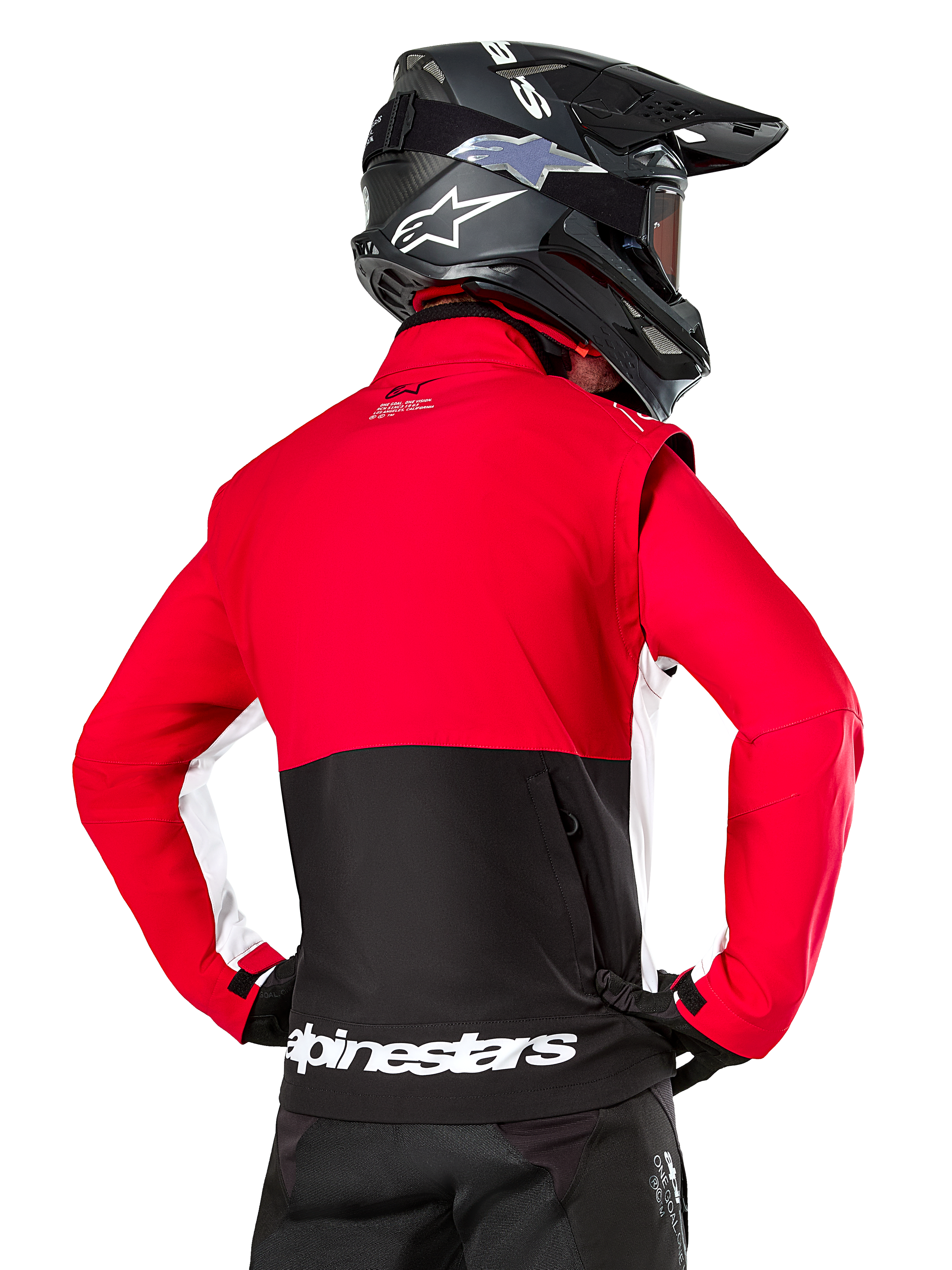 Alpinestars Lite-Dura Softshell Jacket, Black Bright Red White, back view on a motocross rider, red upper body and sleeves with black lower back panel, zippered rear storage pocket, white Alpinestars logo on the bottom hem, worn with a black helmet and pants