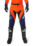 Alpinestars Pro-Dura Hose, Motocross- und Enduro-Hose, Navy, Hot Orange und Weiß, mit schwarzen Einsätzen und weißen Logos, getragen mit schwarzen Offroad-Stiefeln und Handschuhen, professionelle Schutzausrüstung für Trail- und Offroad-Fahrten