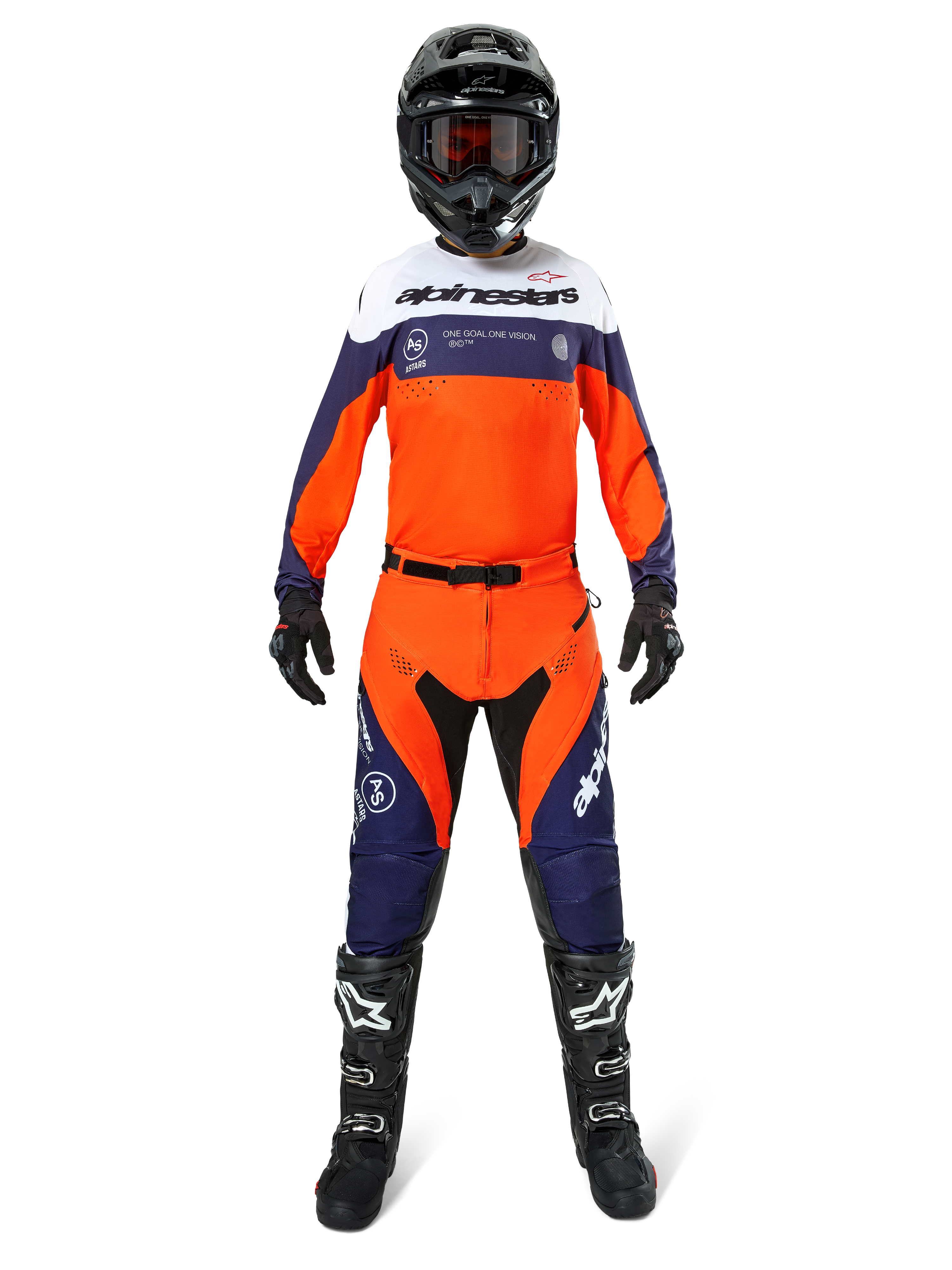Motocross-Fahrer in Alpinestars Pro-Dura Hose in Navy, Hot Orange und Weiß, mit passendem langärmeligem Trikot, schwarzem Helm mit Goggles, schwarzen Handschuhen und schwarzen Motocross-Stiefeln, komplette Offroad-Rennausrüstung.