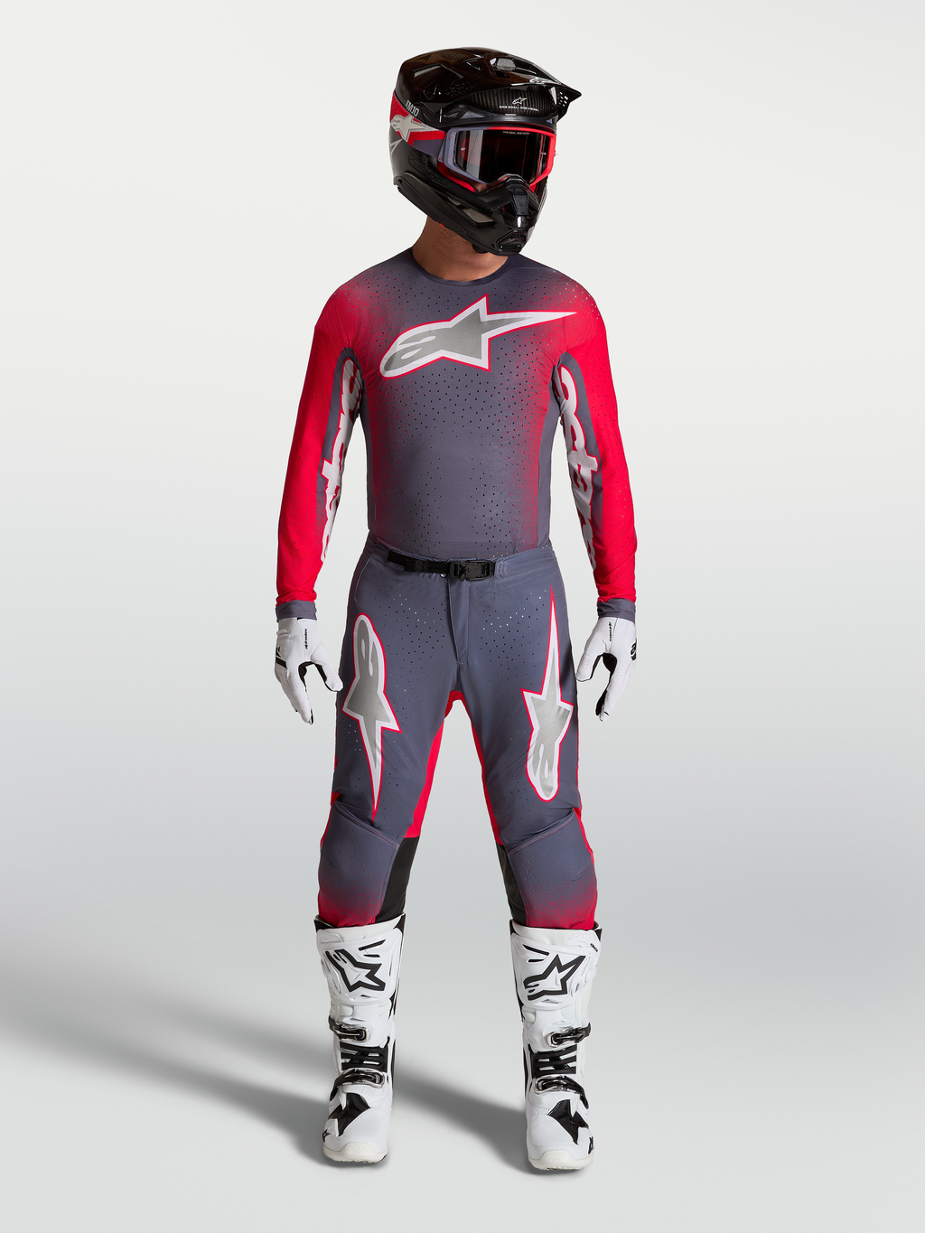 Alpinestars Supertech Hiten AFD Gear Set und Hose, professionelle Motocross-Bekleidung in Grau und Rot-Fluo, athletische Rennpassform für Elite-Fahrer.