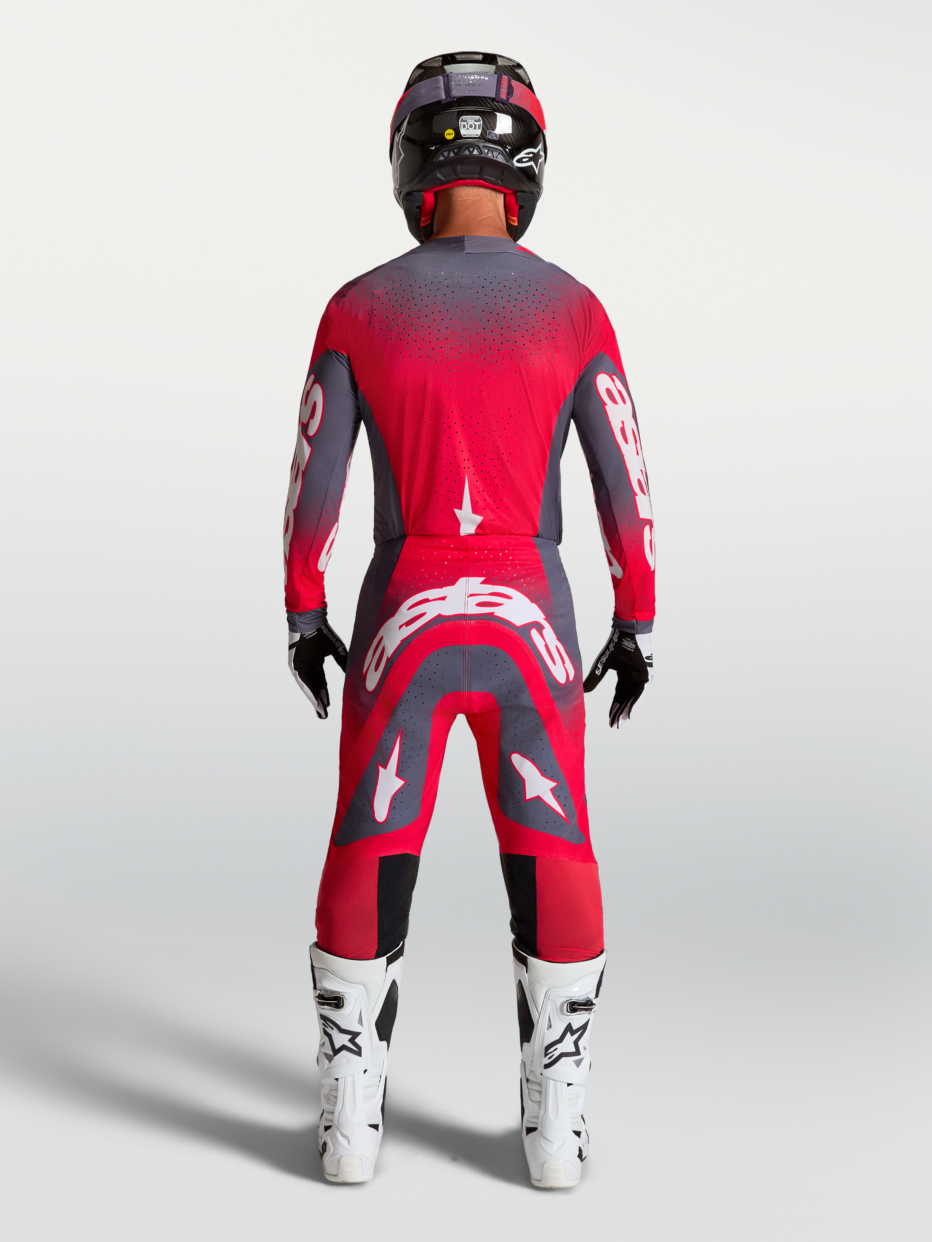 Alpinestars Supertech Hiten AFD Gear Set und Hose, Motocross-Rennbekleidung in Rot Fluo und Grau, Rückansicht am Model.