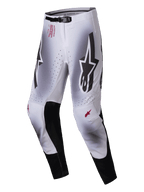Alpinestars 2025 Supertech Maker Hose, Motocross-Hose, Silber und Schwarz, mit großen schwarzen Astars-Logos auf den Oberschenkeln, rotem technischem Branding an der Hüfte, schwarzen Leder-Innenknie-Einsätzen und perforierten Belüftungszonen.