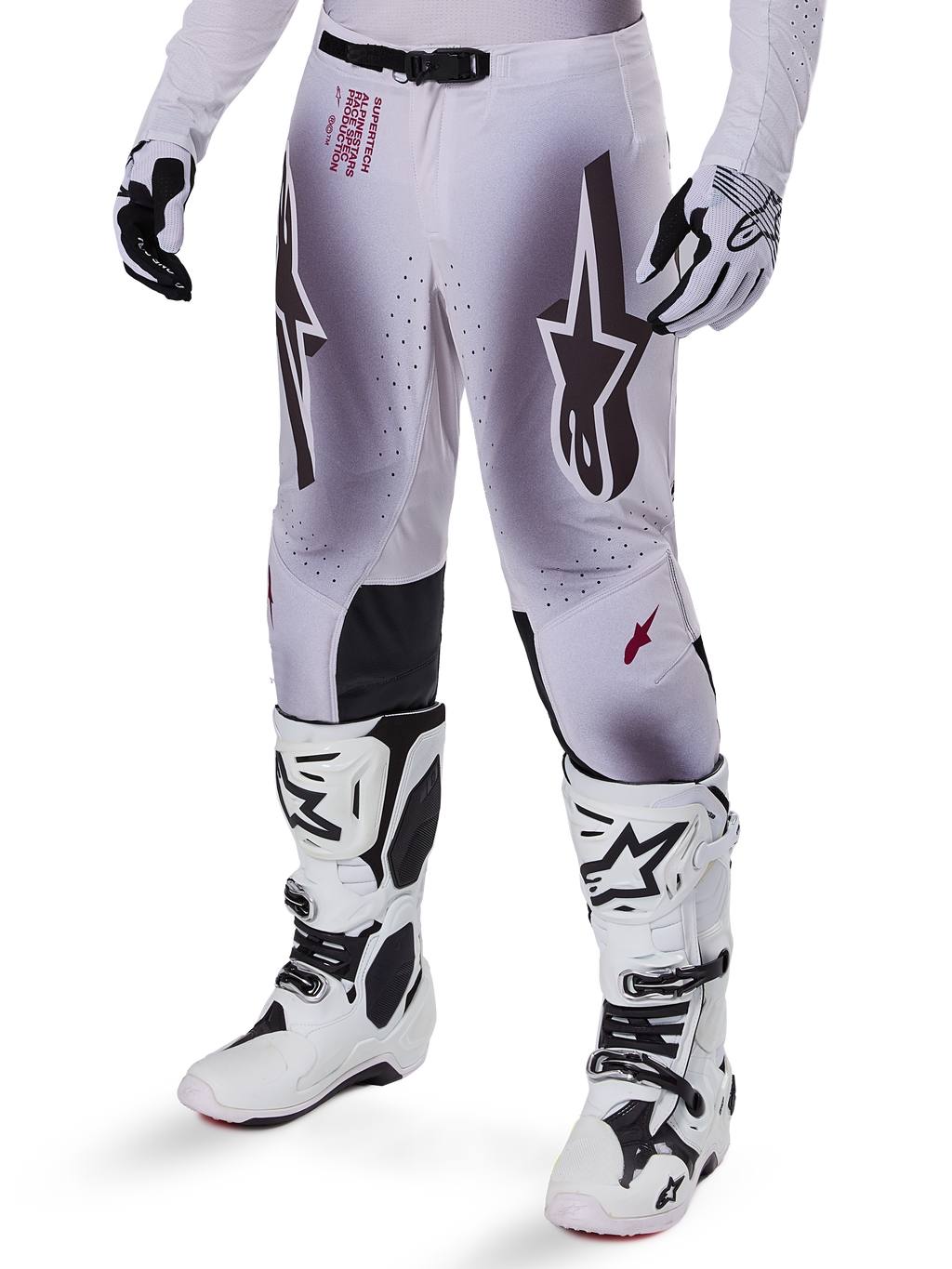 Alpinestars 2025 Supertech Maker Hose, Motocross-Hose, Silber und Schwarz, mit großen Stern-Logos und rotem Schriftzug, abgebildet mit passenden weißen Stiefeln und Handschuhen