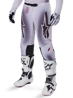 Alpinestars 2025 Supertech Maker Hose, Motocross-Hose, Silber und Schwarz, mit großen Stern-Logos und rotem Schriftzug, abgebildet mit passenden weißen Stiefeln und Handschuhen