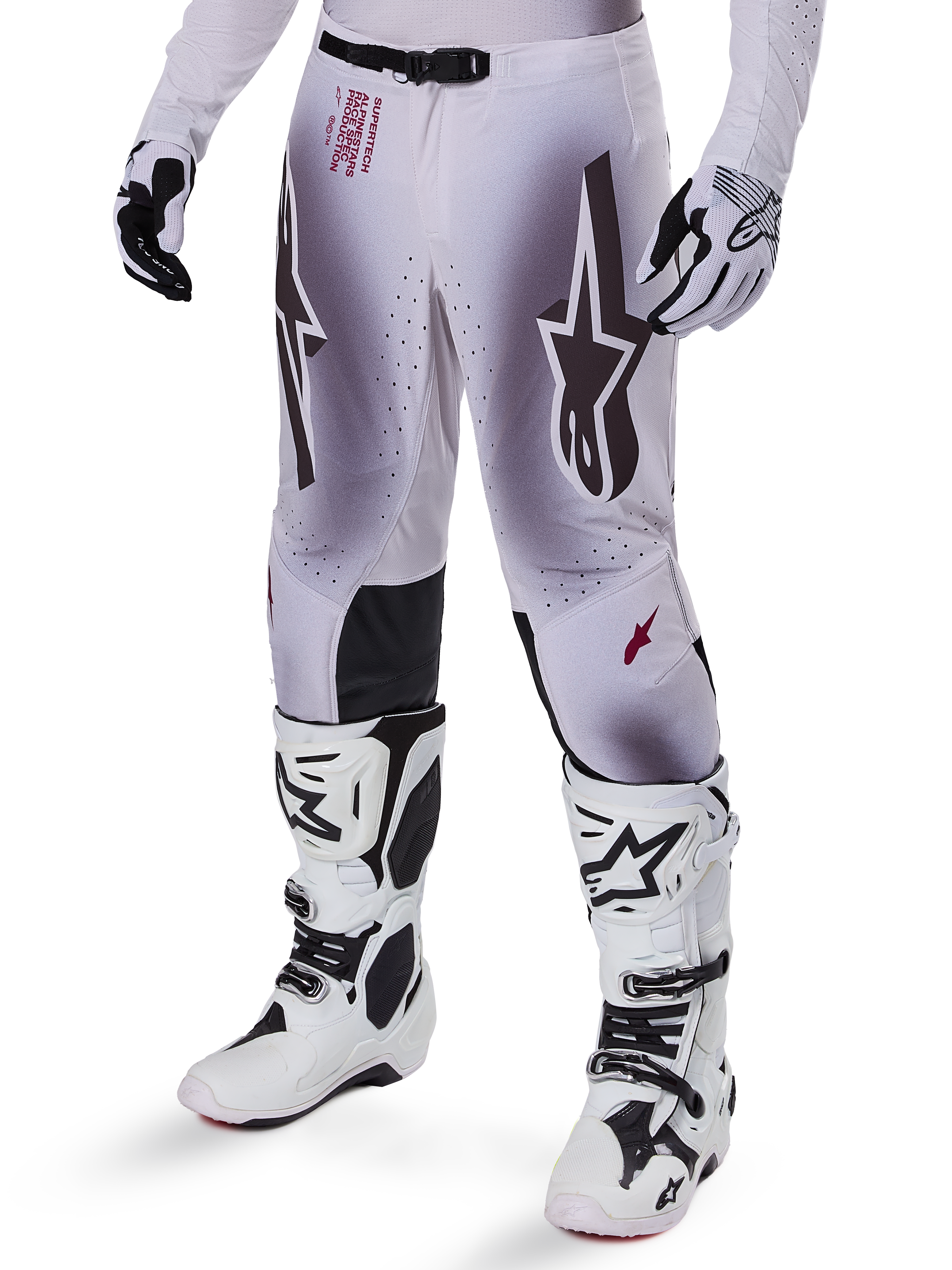 Alpinestars 2025 Supertech Maker Hose, Motocross-Hose, Silber und Schwarz, mit großen Stern-Logos und rotem Schriftzug, abgebildet mit passenden weißen Stiefeln und Handschuhen