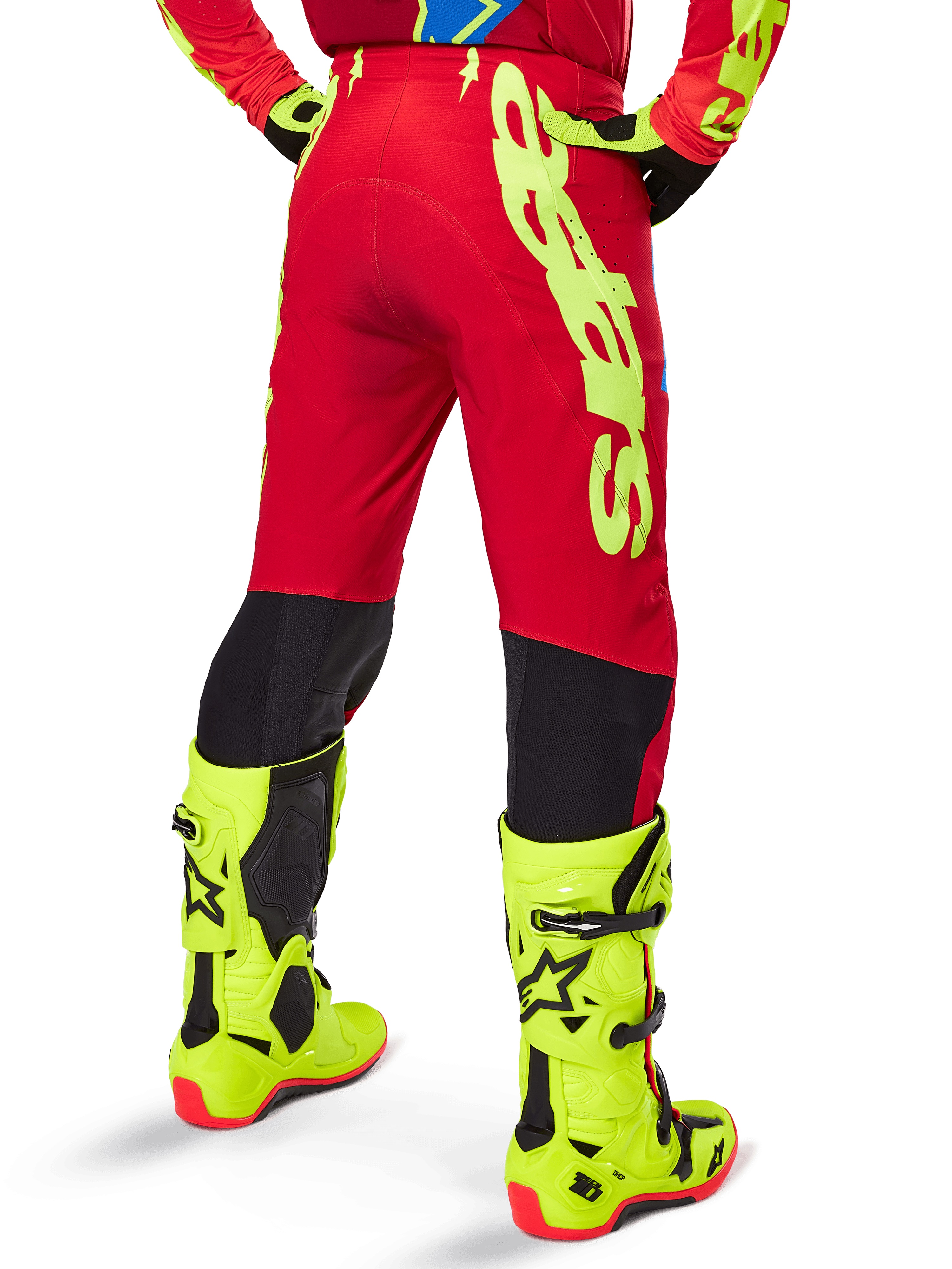 Alpinestars 2025 Supertech Maker Hose, Motocross-Hose, Leuchtendes Rot und Fluo-Gelb, Rückansicht mit großem gelben Branding an der Seite und schwarzen Einsätzen an den Unterschenkeln, kombiniert mit passenden fluogelben Stiefeln und Ausrüstung