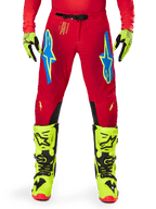 Alpinestars 2025 Supertech Maker Hose, Motocross-Hose, Hellrot und Neongelb, getragen mit passenden neongelben Handschuhen und Stiefeln, blaue und neongelbe Astars-Logos, schwarze Knie-Innenpaneele, athletisches Design für den Offroad-Rennsport