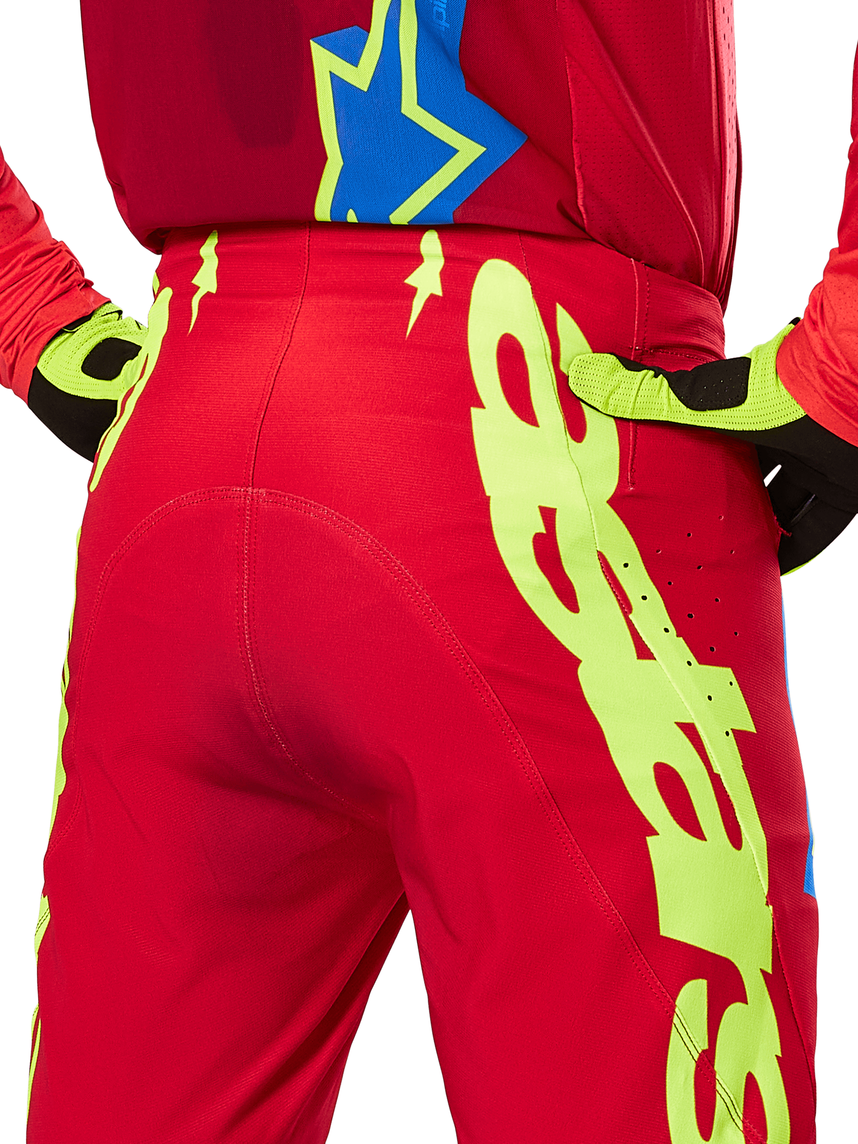 Alpinestars 2025 Supertech Maker Hose, Motocross-Hose, Leuchtendes Rot und Neongelb, Rückansicht mit großen gelben Grafiken auf den Beinen und passenden neongelben und schwarzen Handschuhen, professionelle Offroad-Rennausrüstung
