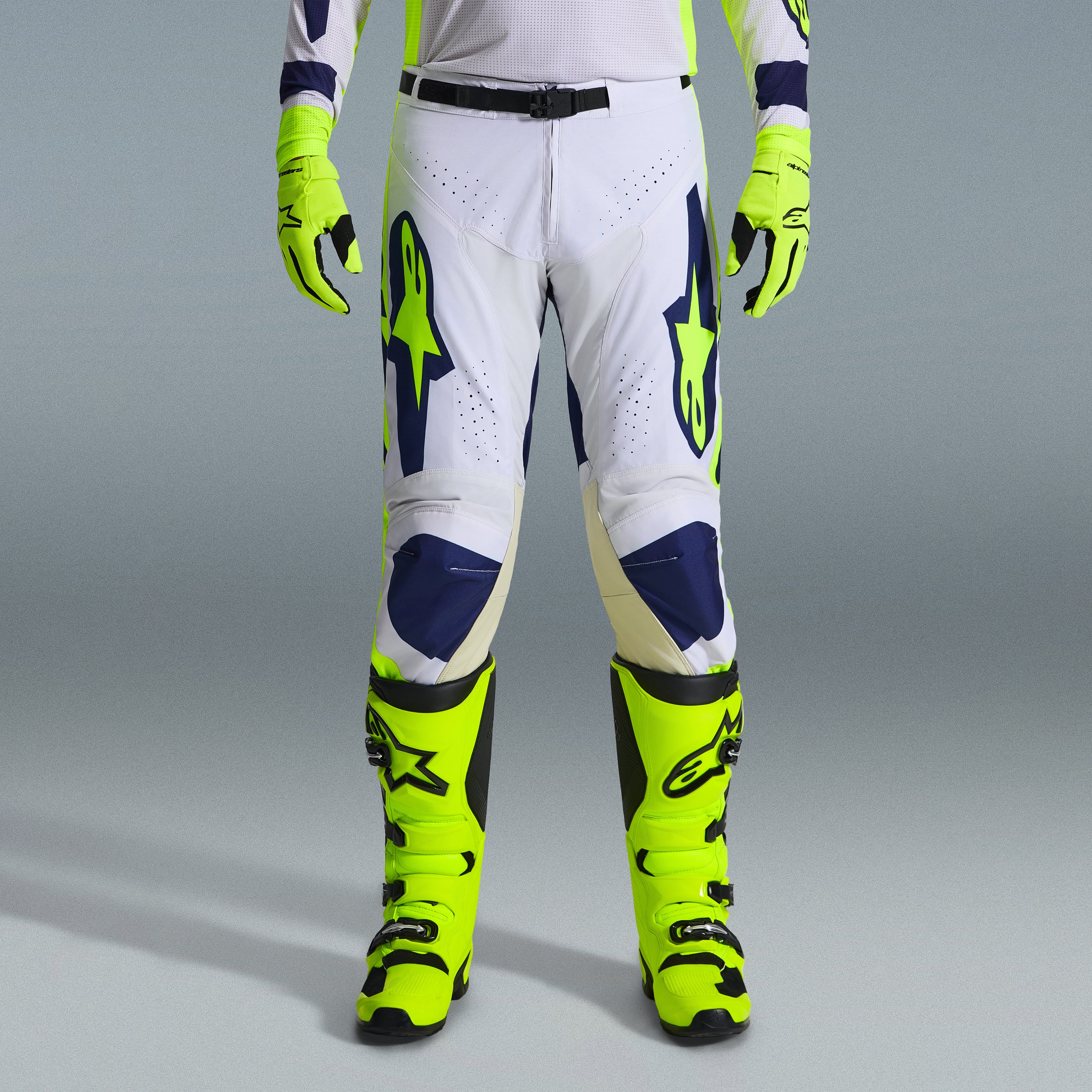 Alpinestars 2026 Racer Air Riway Bekleidungsset, Motocross-Hose in Weiß und Marineblau mit neongelben Akzenten, kombiniert mit passenden neongelben Handschuhen und Stiefeln, mit ergonomischem Design und belüfteten Einsätzen für den Offroad-Rennsport.