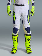 Alpinestars 2026 Racer Air Riway Hose, Motocross-Hose, Hellgrau, Gelb Fluo und Blau, getragen mit passenden neongelben Handschuhen und Stiefeln, ausgestattet mit perforierten Vorderseiten für optimale Belüftung und markantem blau-gelbem Branding, athletisches Design für Offroad-Performance