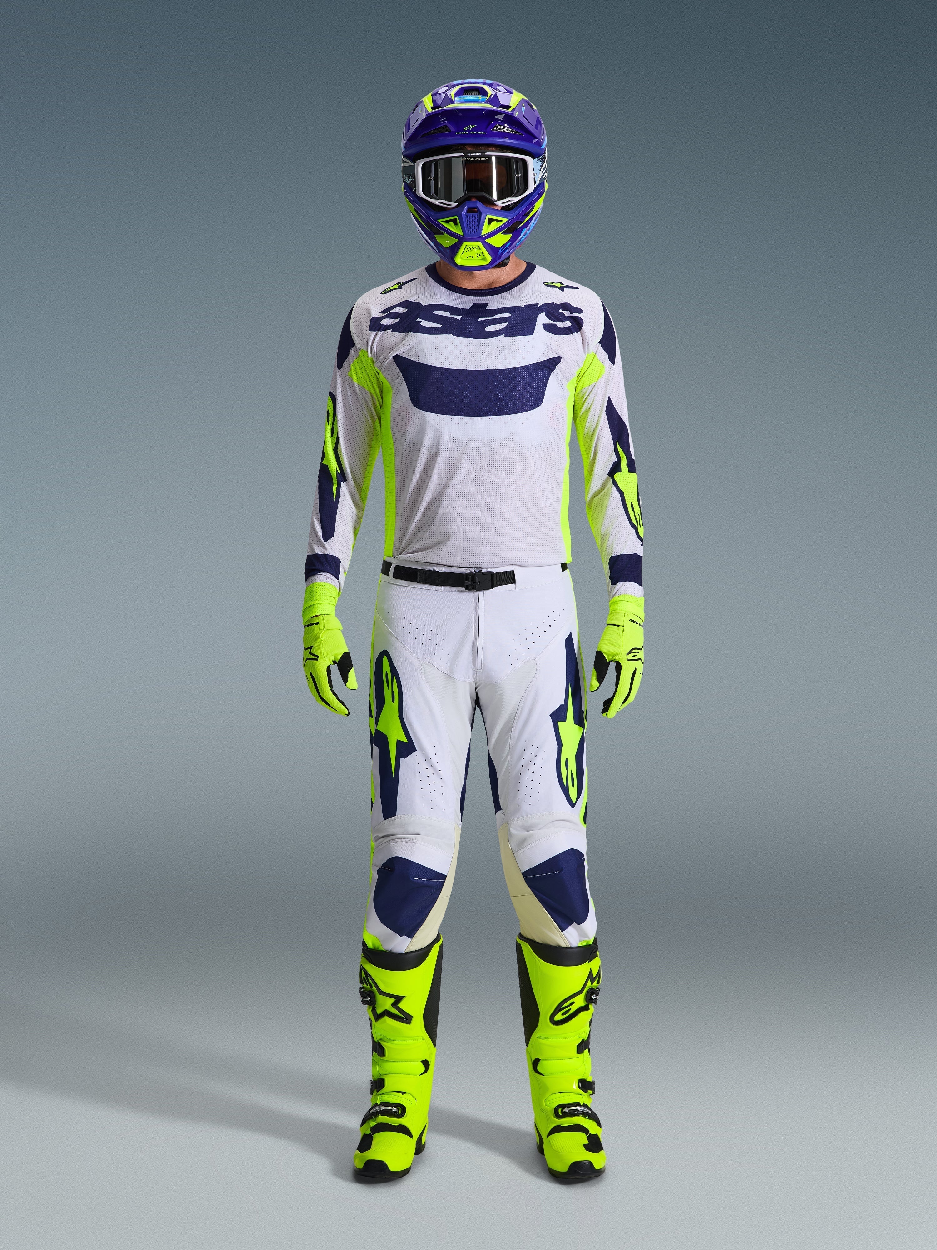 Alpinestars 2026 Racer Air Riway Gear Set, Motocross-Ausrüstung, weißes Trikot mit blauem Logo und neongelben Akzenten, weiße Hose mit blauen und gelben Mustern, lila und gelber Helm, neongelbe Stiefel und Handschuhe, komplettes Offroad-Kit