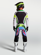 Alpinestars Supertech Dyna Hose, Motocross-Hose in Helllila und Grün, Rückansicht eines Fahrers im Rennkit.