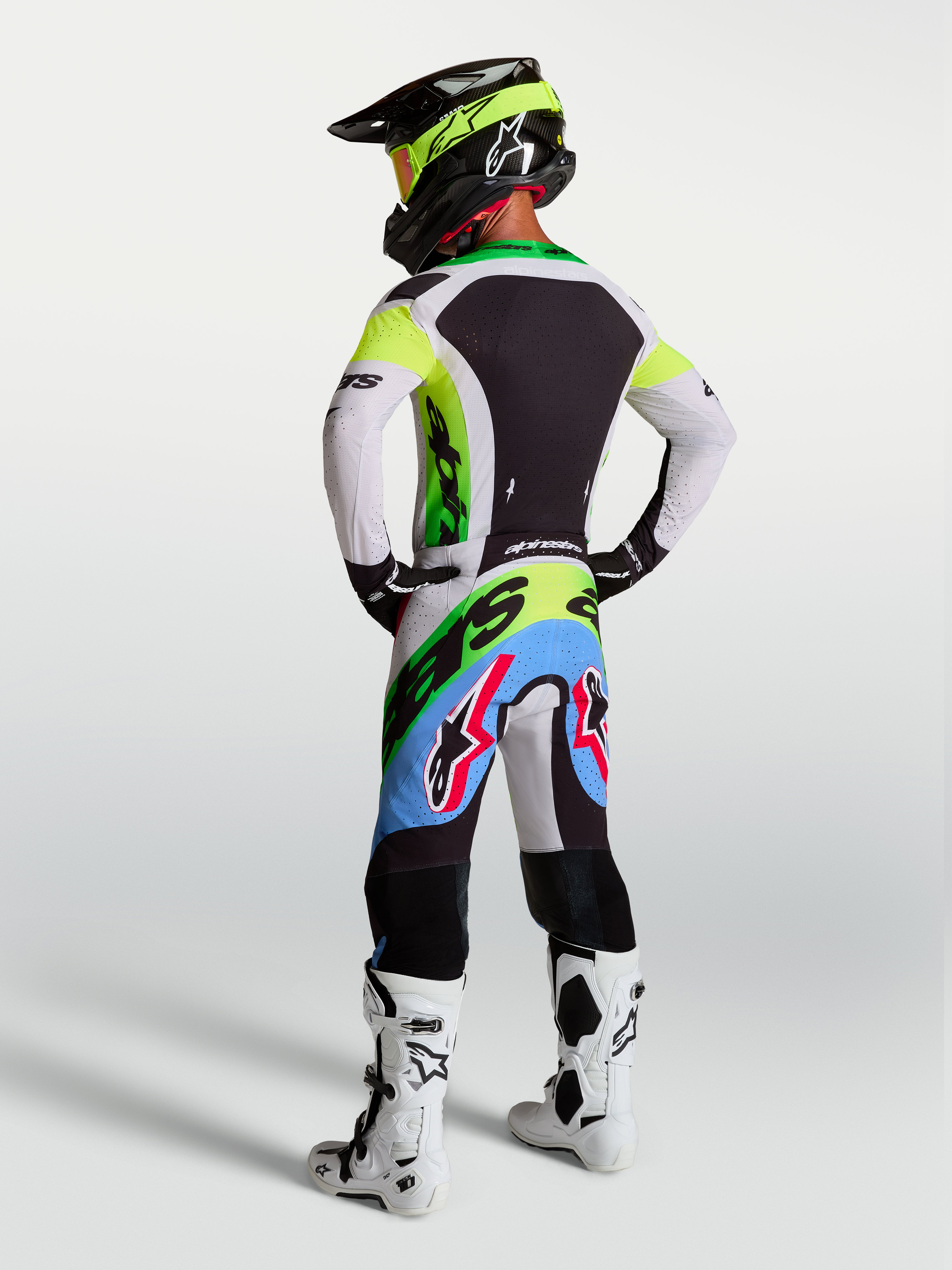 Alpinestars Supertech Dyna Motocross-Ausrüstung für Herren, Supertech Dyna Hose und Trikot in Grün Fluo, Schwarz und Helllila, Rückansicht eines Fahrers.