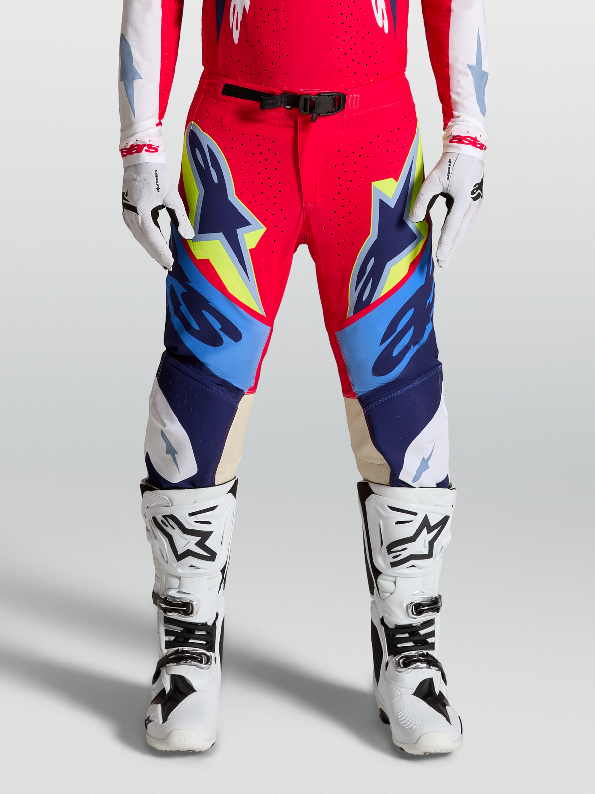 Alpinestars Supertech Dyna Hose, Motocross-Hose f61r Herren, Rot und Blau mit gelben Akzenten, getragen mit wei62en Stiefeln und Handschuhen, SX1 Magnetverschluss und Ziegenleder-Kniepanels