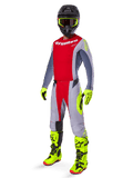 Motocross rider wearing the Alpinestars 2025 Techstar Melt Gear Set, red and gray jersey and pants, vibrant neon yellow gloves and boots, black helmet, complete off-road racing kit