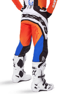 Alpinestars 2025 Techstar Melt Hose, Motocross-Hose, Orange und Blau, Rückansicht mit großem weißem Branding am Gesäß, getragen mit passendem orangefarbenem Jersey und weißen Tech 10 Stiefeln, strapazierfähige Offroad-Rennausrüstung