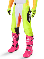 Alpinestars 2025 Techstar Melt Hose, Motocross-Hose, Neongelb mit weißen und orangen Akzenten, schwarze Muster an den Seiten, getragen mit leuchtend rosa Motocross-Stiefeln und neongelben Handschuhen, perforierte Belüftung, strapazierfähige Offroad-Rennausrüstung
