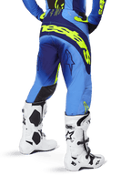 Alpinestars 2025 Techstar Melt Pants, Motocross Pants, Blue and Yellow Fluo, back view showing large yellow branding on the seat and thighs, worn with white motocross boots and matching blue jersey, athletic race fit for off-road riding