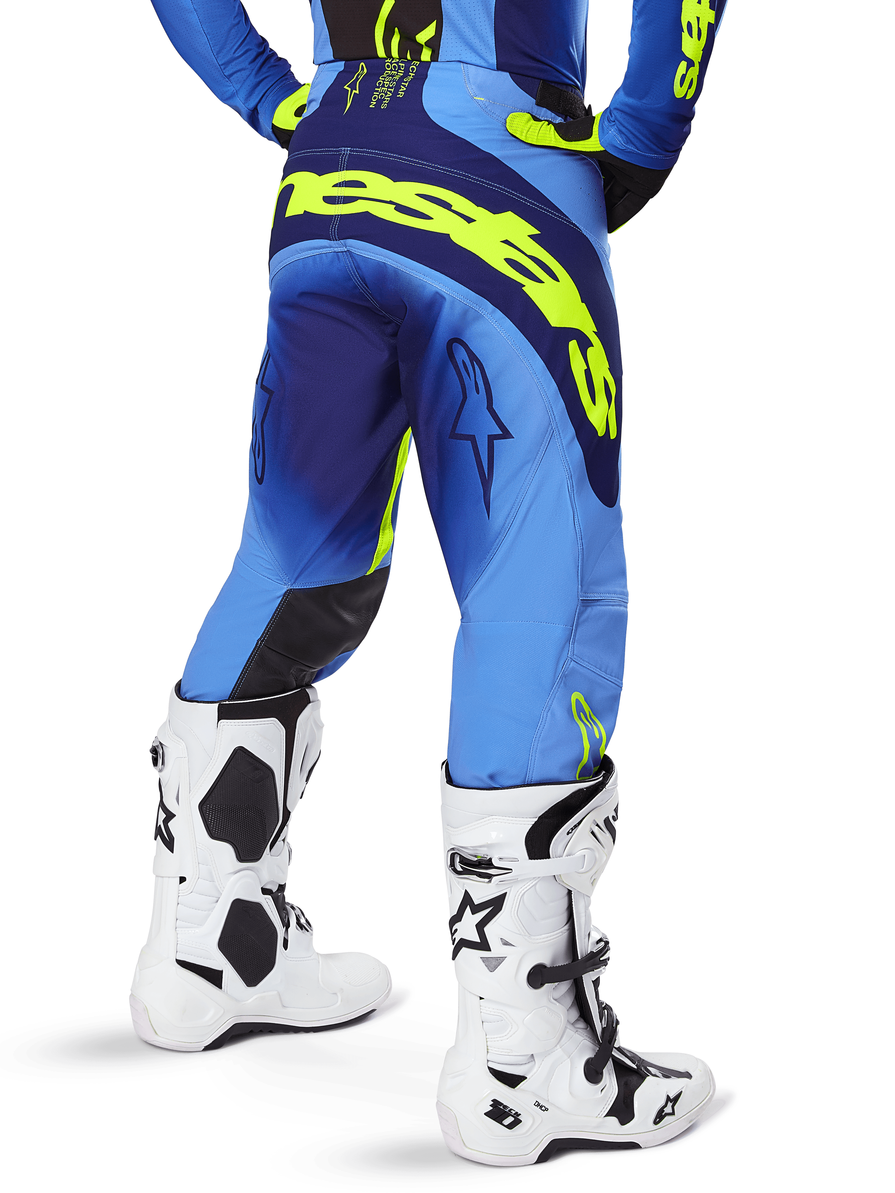 Alpinestars 2025 Techstar Melt Pants, Motocross Pants, Yellow Fluo Blue, rear view featuring large yellow branding across the seat and dark blue accents, worn with white Alpinestars Tech 10 boots and a matching jersey.