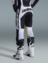Alpinestars 2026 Racer Riway Pants, Motocross Pants, White and Black, back view showing bold black branding on the seat and sides, tan goat leather inner knee panels, worn with matching white and black motocross boots