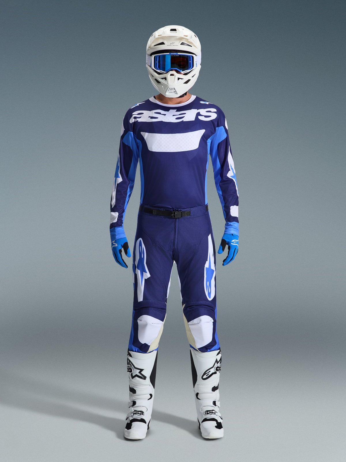 Alpinestars 2026 Racer Riway Gear Set, komplette Motocross-Rennausrüstung, marineblaues und hellblaues Jersey mit weißem „astars“-Schriftzug, passende Hose mit weißen Akzenten, weißer Helm mit blauer Brille und weiße Offroad-Stiefel.