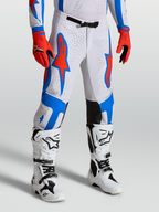 Alpinestars Supertech Vesta Hose, Motocross-Hose in Weiß und Rot mit blauen Stern-Grafiken, athletische Passform am Model, Offroad-Performance-Design.
