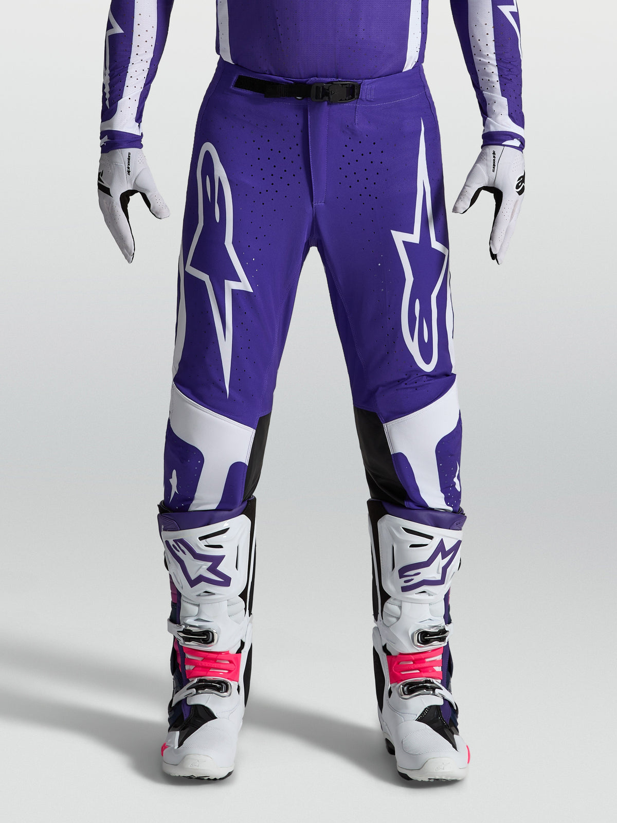 Alpinestars Supertech Vesta Hose, Motocross-Hose in Blau und Weiß, athletische Passform mit robuster Ripstop-Konstruktion, getragen mit Offroad-Stiefeln.