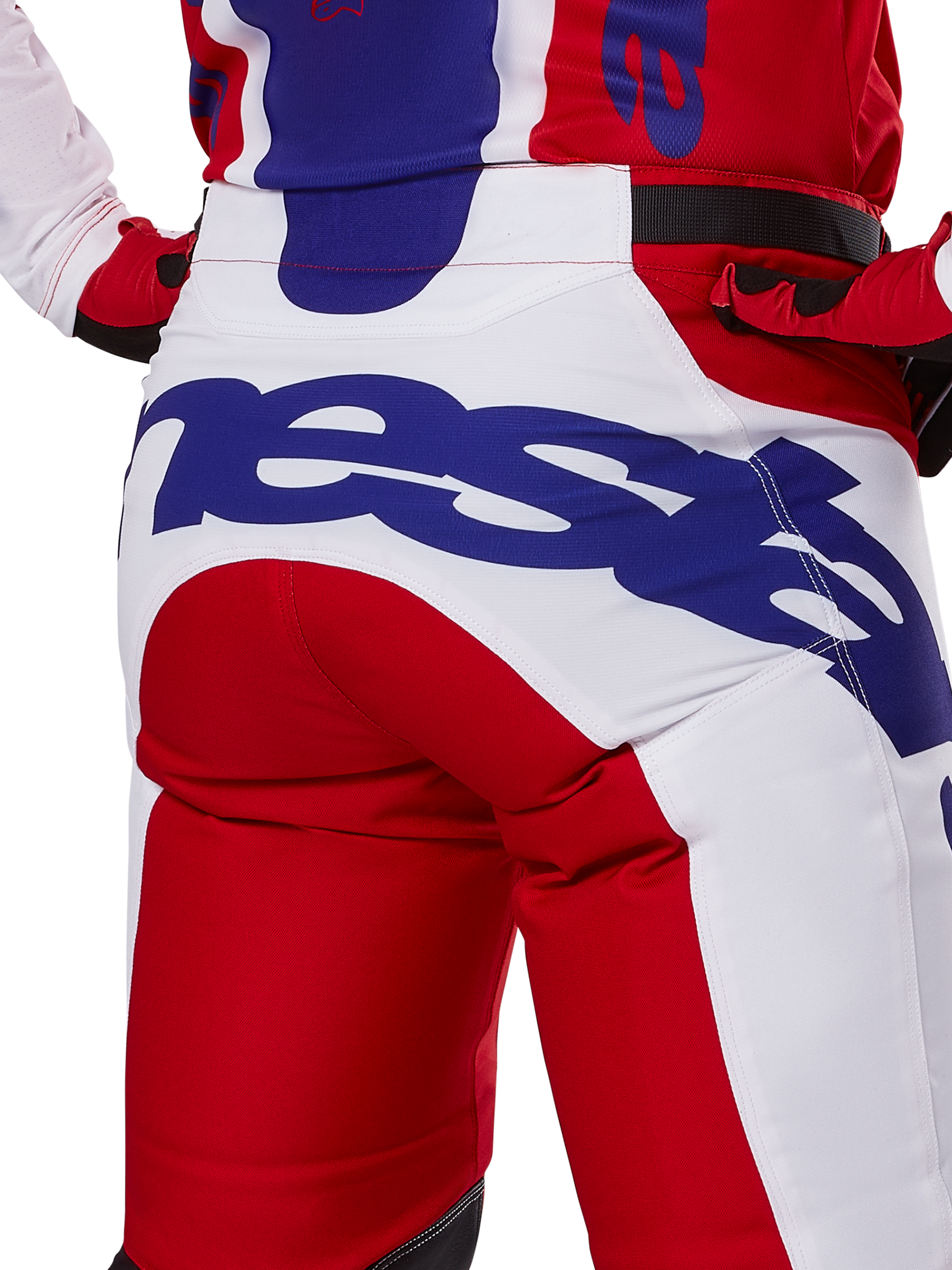Alpinestars 2025 Racer Veil Hose, Motocross-Hose, Leuchtendes Rot und Weiß mit blauem Branding, Detailansicht der Rückseite des Gesäßbereichs mit einem großen Alpinestars-Logo, getragen als Teil eines abgestimmten Offroad-Rennoutfits