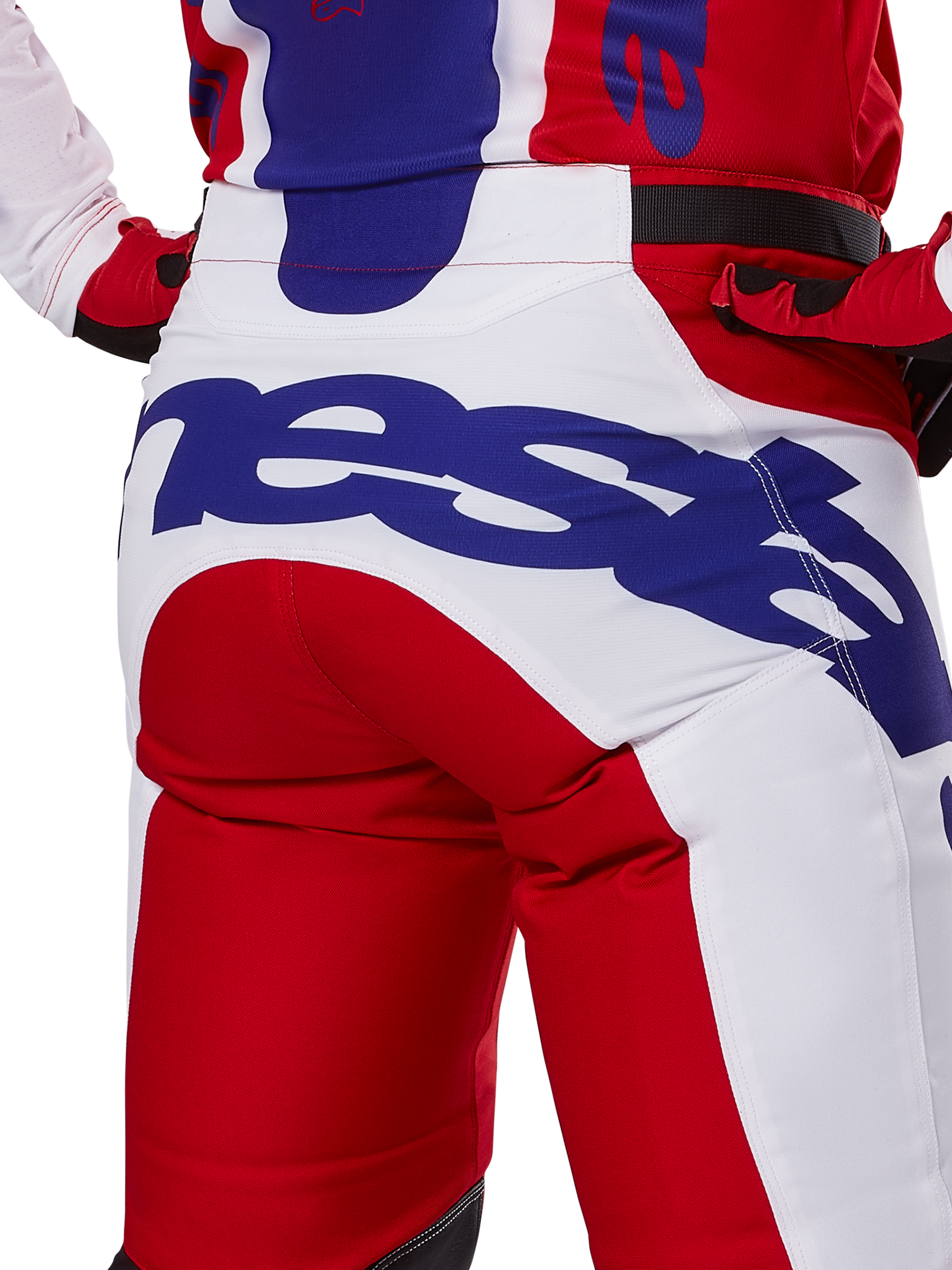 Alpinestars 2025 Racer Veil Hose, Motocross-Hose, Leuchtendes Rot und Weiß mit blauem Branding, Detailansicht der Rückseite des Gesäßbereichs mit einem großen Alpinestars-Logo, getragen als Teil eines abgestimmten Offroad-Rennoutfits