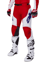 Alpinestars 2025 Racer Veil Hose, Motocross-Hose, Leuchtendes Rot und Weiß, mit blauen Alpinestars-Logos und schwarzen Leder-Innenknie-Einsätzen, getragen mit passenden roten Handschuhen und weißen Motocross-Stiefeln, abgestimmtes Ausrüstungsset für Offroad-Rennen