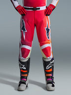 Alpinestars 2026 Racer Portl Hose, Motocross-Hose, Rot, Hellgrau und Dunkelgrau, getragen mit passenden roten Handschuhen und mehrfarbigen Stiefeln, mit markanten Alpinestars-Sternlogos auf den Oberschenkeln und weißen Akzenten, sportliches Design für Offroad-Rennsport