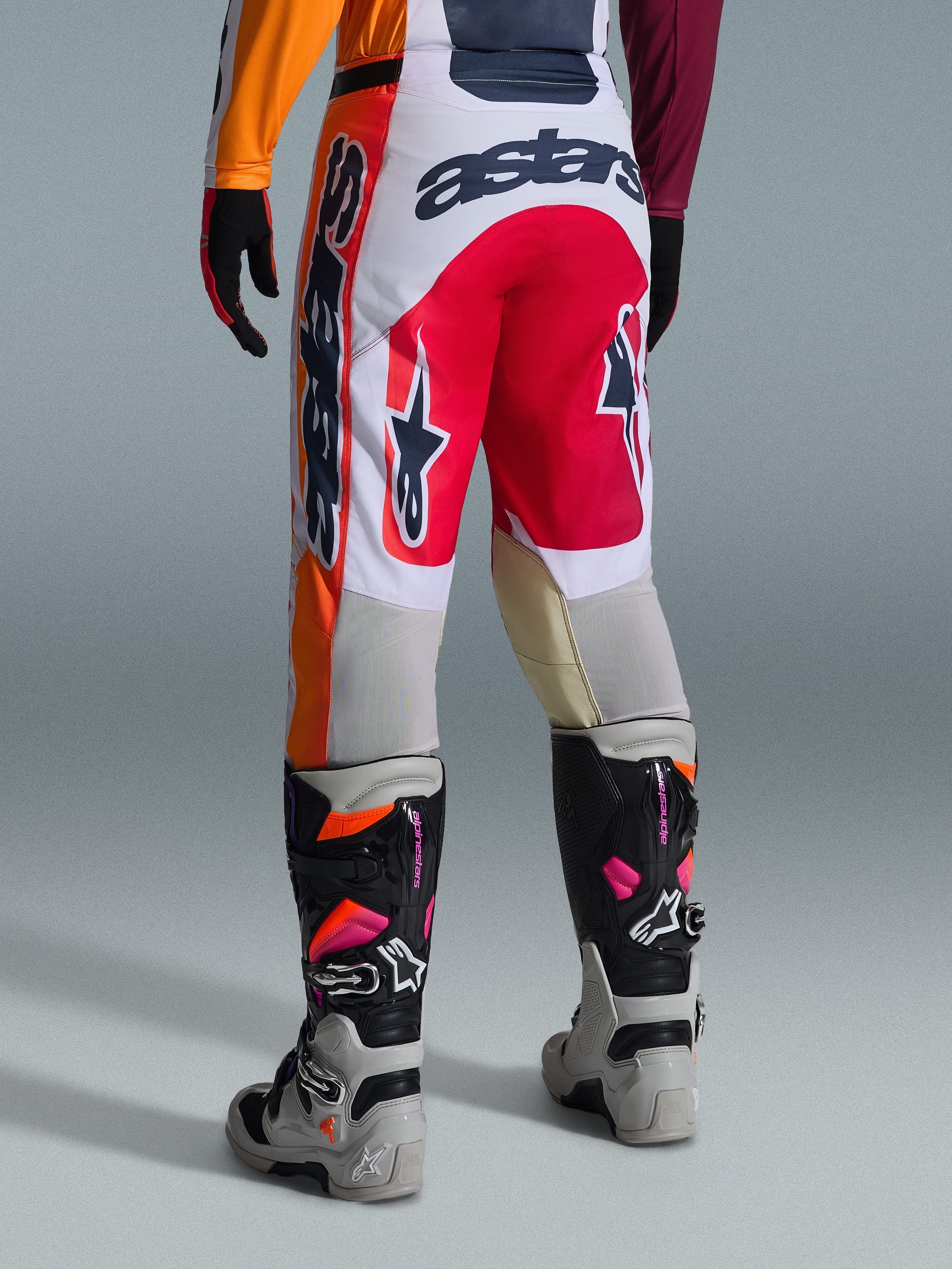 Alpinestars 2026 Racer Portl Hose, Motocross-Hose, Rot, Hellgrau und Dunkelgrau, Rückansicht mit markanten Branding- und Logo-Details, kombiniert mit abgestimmten Motocross-Stiefeln und Handschuhen, Performance-Ausrüstung für den Offroad-Rennsport