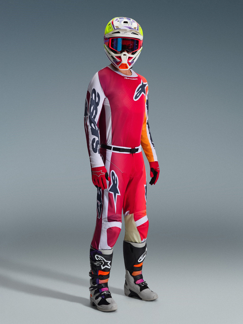 Alpinestars 2026 Racer Portl Hose, Motocross-Hose, Rot, Hellgrau und Dunkelgrau, getragen als Teil einer kompletten Rennausrüstung mit passendem Jersey, roten Handschuhen, buntem Helm mit blauer Brille und grauen Stiefeln, strapazierfähige Konstruktion für Offroad-Motocross-Performance.