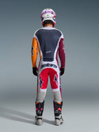 Motocross-Fahrer in der Rückansicht, trägt die 2026 Racer Portl Hose in Rot, Hellgrau und Dunkelgrau, mit „astars“-Branding am Gesäß, kombiniert mit einem mehrfarbigen Trikot, einem weißen Helm und technischen Rennstiefeln.