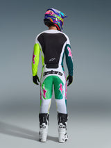 Motocross-Fahrer von hinten in der Alpinestars 2026 Racer Portl Hose in Grün-Weiß-Schwarz, passendes Trikot mit pinkfarbenen Stern-Logos, mehrfarbiger „astars“-Helm und weiß-schwarze Stiefel, abgestimmte Offroad-Rennausrüstung.