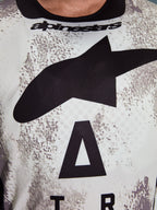 Alpinestars 2026 Racer Lahnd Trikot, Nahaufnahme des Brustbereichs, Sand Camo-Muster mit großem schwarzem Stern-Logo und Alpinestars-Schriftzug, atmungsaktives Performance-Polygewebe für Offroad-Fahrten