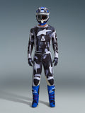 Alpinestars 2026 Racer Lahnd Gear Set, Motocross-Outfit, Schwarz und Weiß mit abstraktem Iron Camo-Muster, kombiniert mit blau-weißem Helm und leuchtend blauen Stiefeln, komplette Rennausrüstung für Offroad-Performance