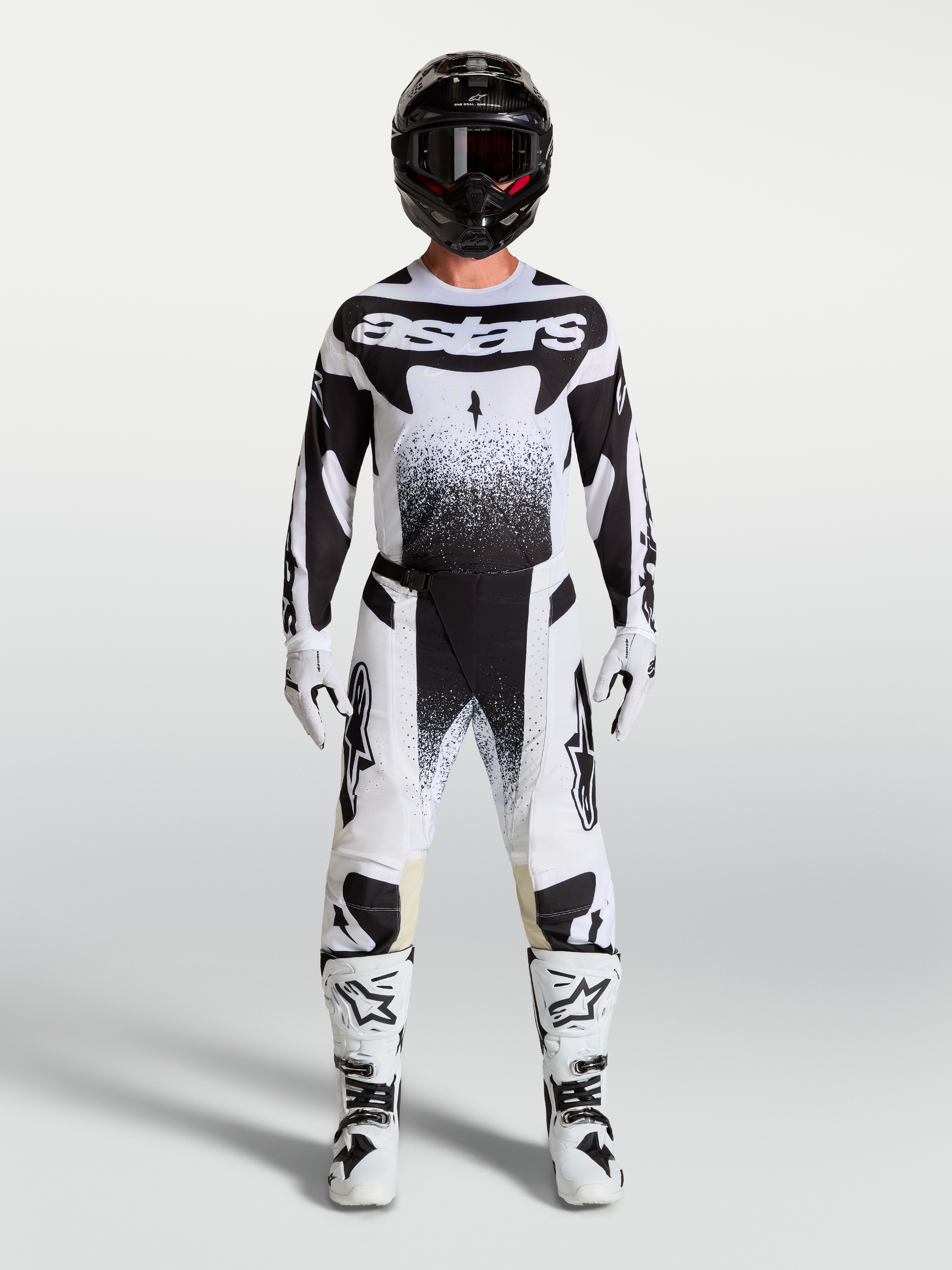 Alpinestars Techstar Swan Hose und Trikot, Motocross-Rennausrüstung für Herren, Weiß und Schwarz, getragen von einem Model mit passenden MX-Stiefeln und Helm