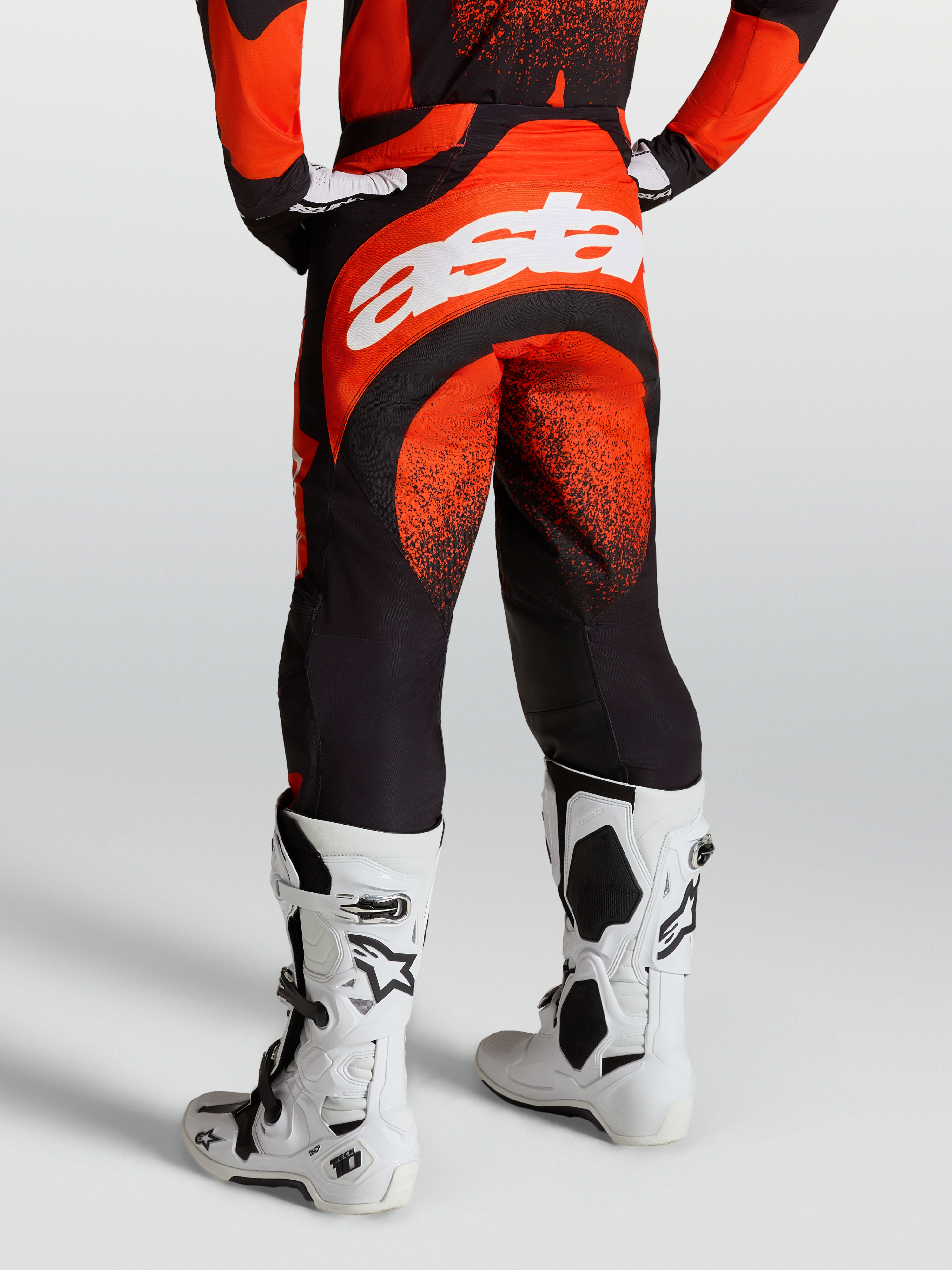 Alpinestars Techstar Swan Hose, Motocross-Rennhose f r Herren, Rot und Schwarz, r ckseitiges Astar-Branding, getragen mit wei en Tech 10 Stiefeln