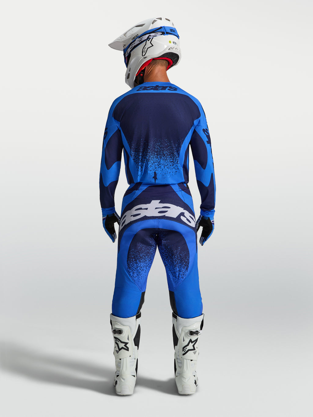 Alpinestars Techstar Swan Motocross-Hose für Herren in Blau und Dunkelblau, Rückansicht mit weißen Stiefeln.